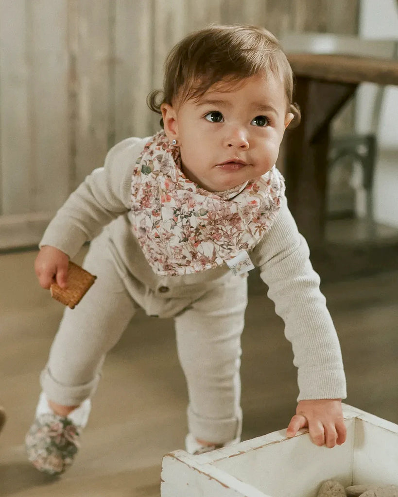 Vue portée du bandana pour bébé fille beige à imprimé fleuri de la marque Bobine Paris.