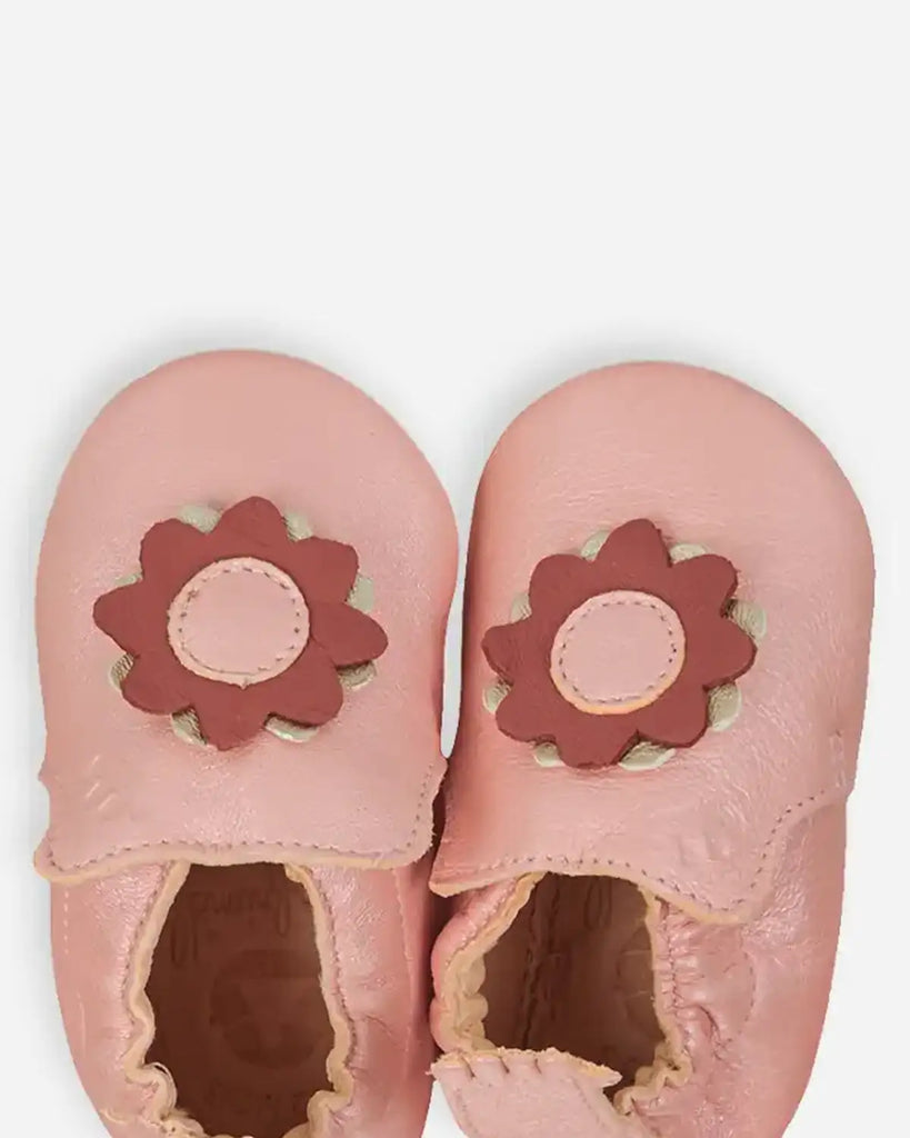 Zoom des chaussons pour bébé fille en cuir mou rose agrémenté d'une fleur rouge de la marque Bobine Paris.
