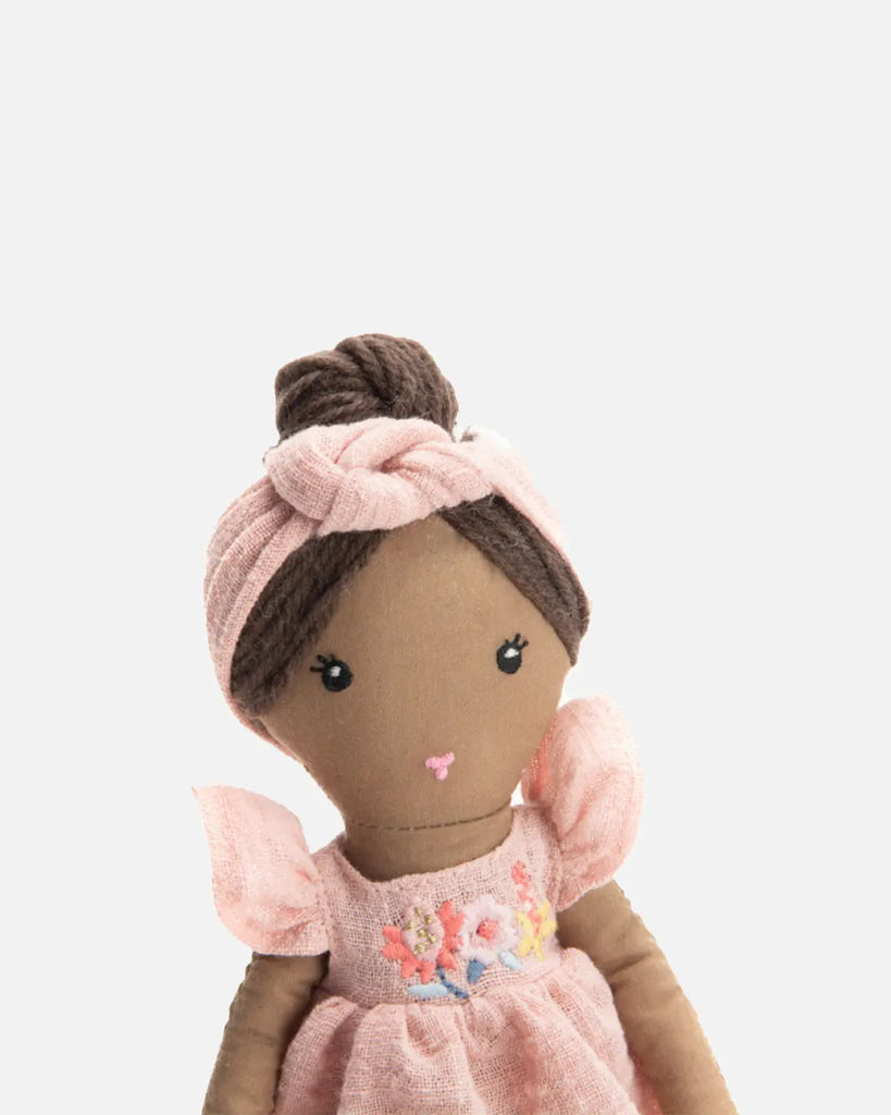 Zoom de la poupée pour bébé vêtue d'une robe rose de la marque Bobine Paris.
