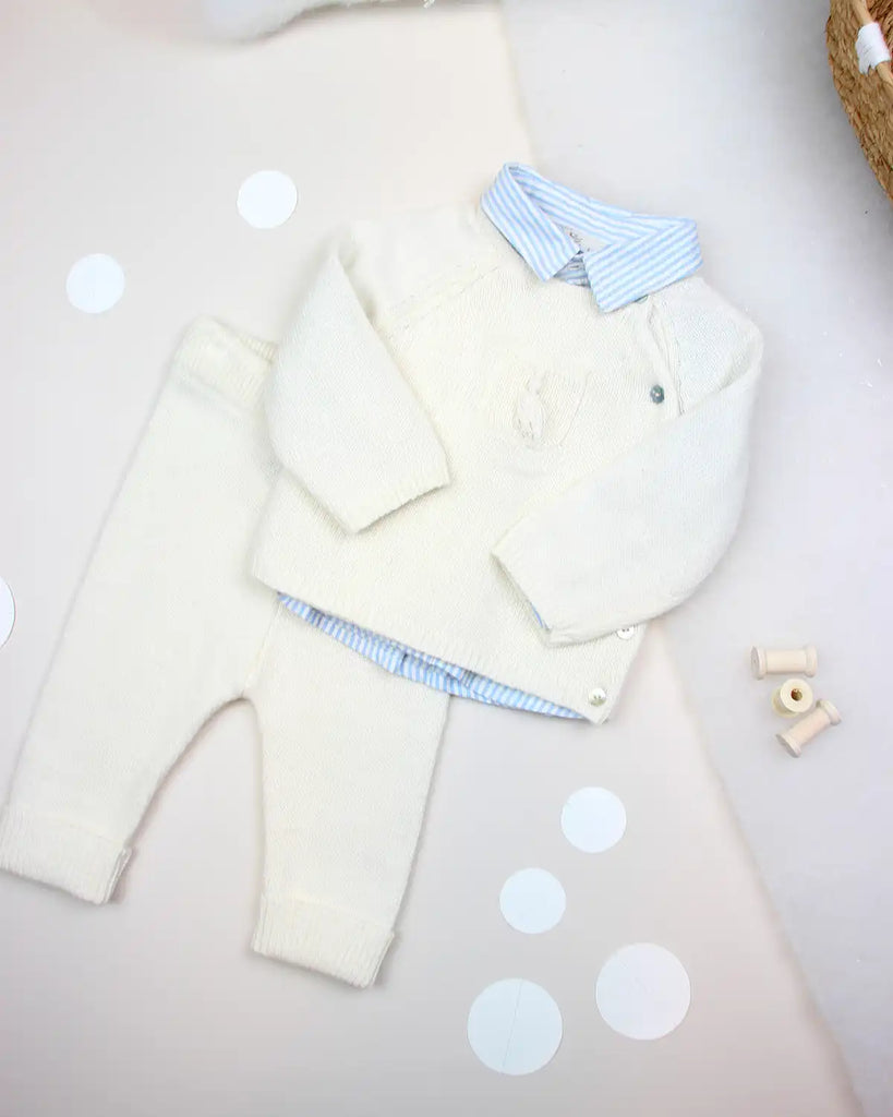 Look avec le pull bébé cache-coeur avec pompon écru en laine et cachemire de la marque Bobine, une chemise à rayures bleues  et un pantalon assorti.