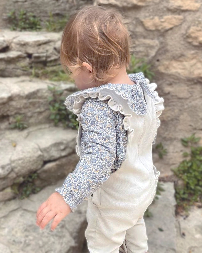 Vue porté du dos de la salopette en velours tricotée écrue pour bébé fille 