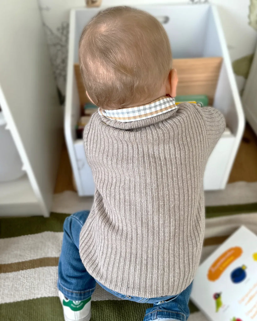 Vue de dos du petit garçon portant le pull pour bébé à col rond beige clair de la marque Bobine Paris.