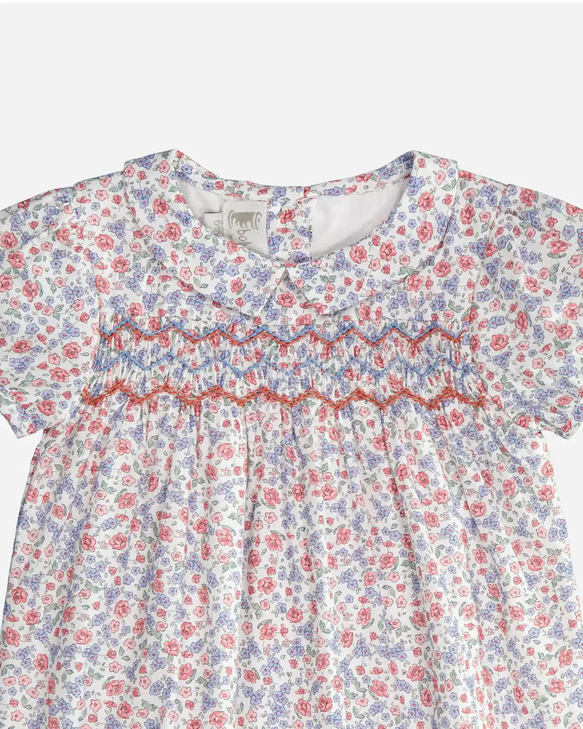 Zoom de la robe pour bébé fille en coton à fleurs roses et bleues avec manches courtes bouffantes, col Claudine pointu et broderie rose et bleue de la marque Bobine Paris.