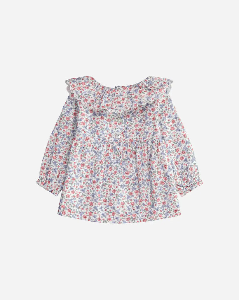 Vue de dos de la blouse à volants et à motif fleuri rose et bleu pour bébé fille de la marque Bobine Paris. 