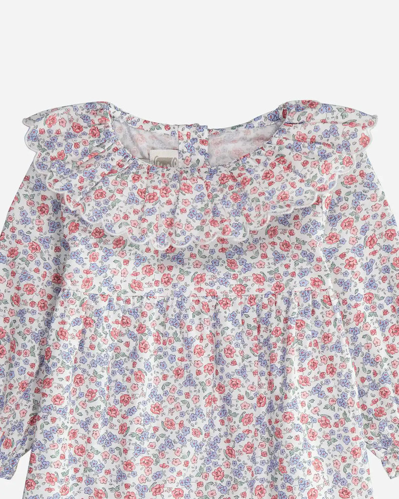 Zoom de la blouse à volants et à motif fleuri rose et bleu pour bébé fille de la marque Bobine Paris. 