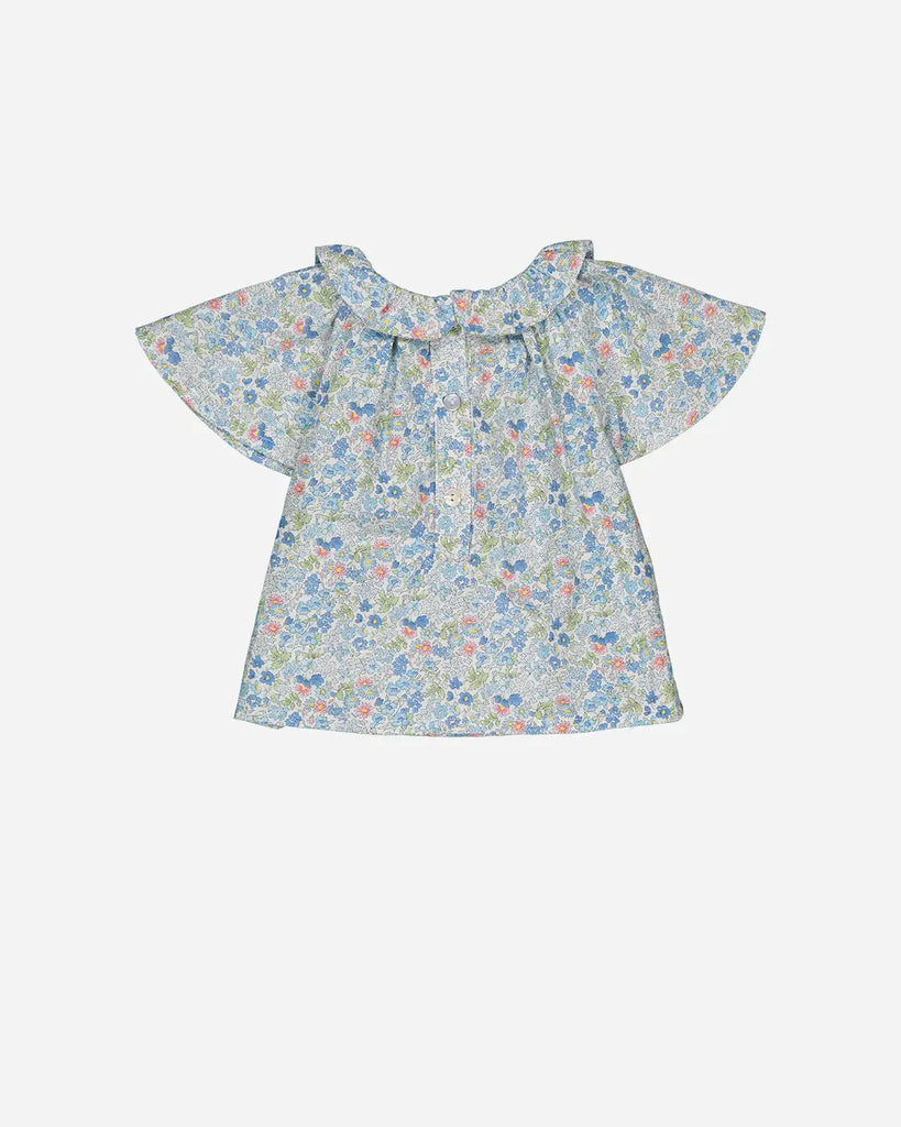 Vue de dos de la blouse à col volanté pour bébé fille à motifs fleuris bleus de la marque Bobine Paris.