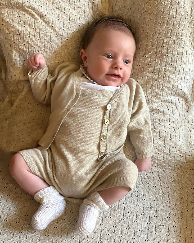 Photo portée de la salopette bébé courte en laine et cachemire beige layette de la marque Bobine Paris.