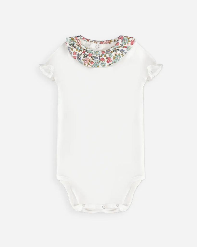 Body pour bébé fille blanc avec un col volanté à fleurs bleues et roses de la marque Bobine paris.