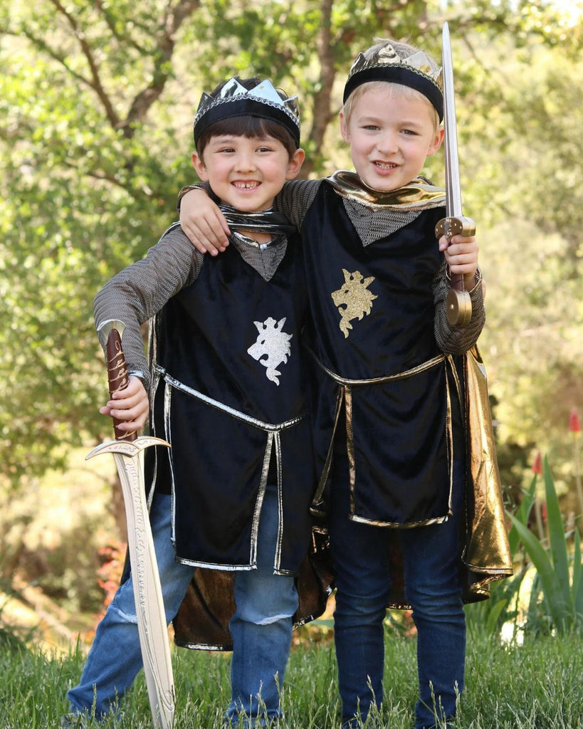  Petits garçons portant un déguisement de chevalier composé d'une tunique noire, d'une cape métallisée dorée et d'une couronne