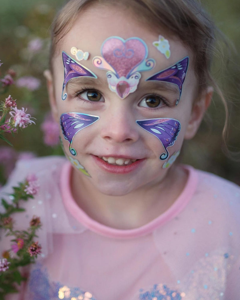 Petite fille avec des stickers de visage violet, pour enfants, en forme de papillon