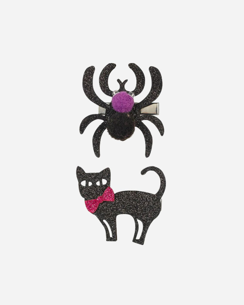 Une barrette araignée noire paillettée avec un pompon violet et un pompon noir et une barrette chat noir pailletté avec un noeud rose