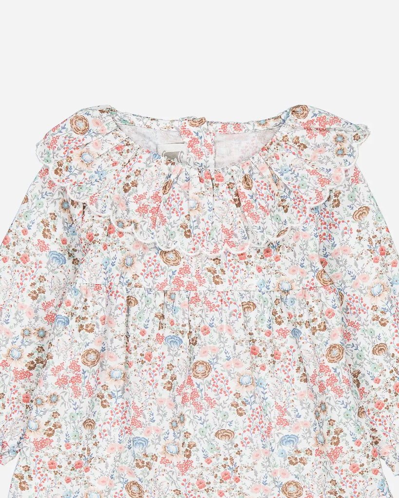 Léger zoom de la blouse pour bébé fille à col volanté et à fleurs colorées de la marque Bobine Paris.