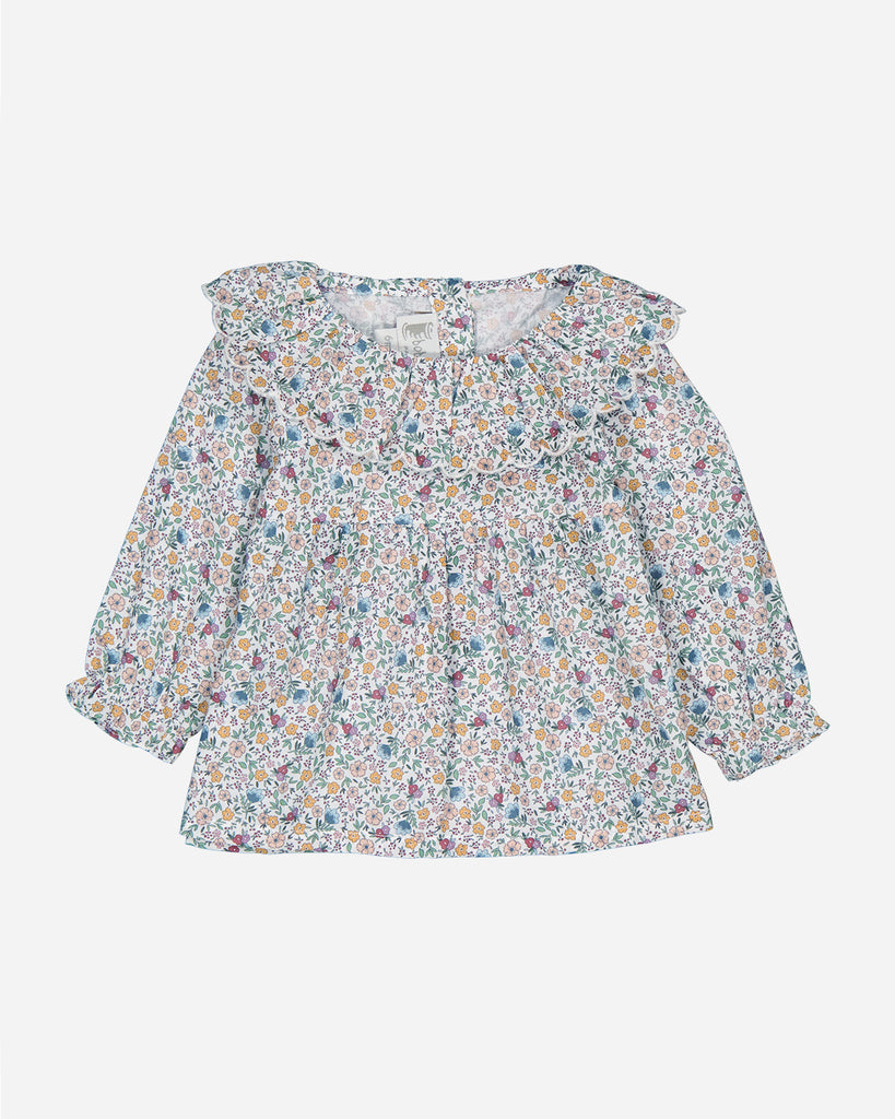 Dos d'une blouse Marguerite au tissu fleurs multicolores avec des poignets volantés.