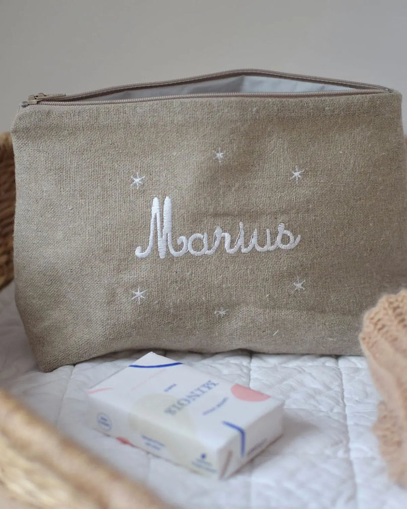Zoom sur l'exemple de trousse de toilette pour bébé beige personnalisable de la marque Bobine Paris avec le prénom "Marius".