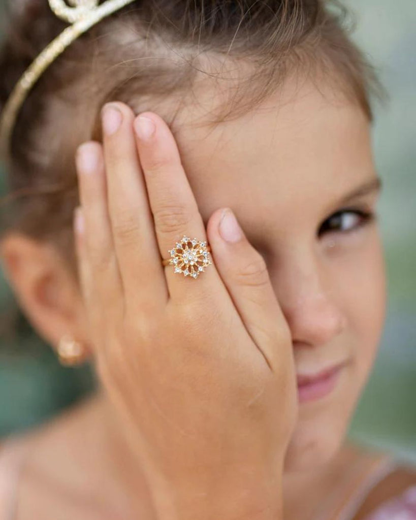 Fille portant un collier et une bague avec un flocon doré à diamant
