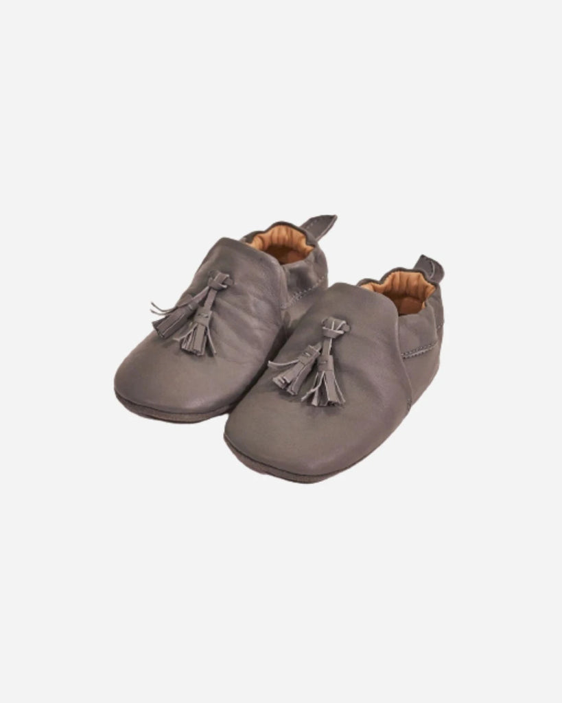 Vue du côté des chaussons pour bébé en cuir gris à pompon de la marque Bobine Paris.