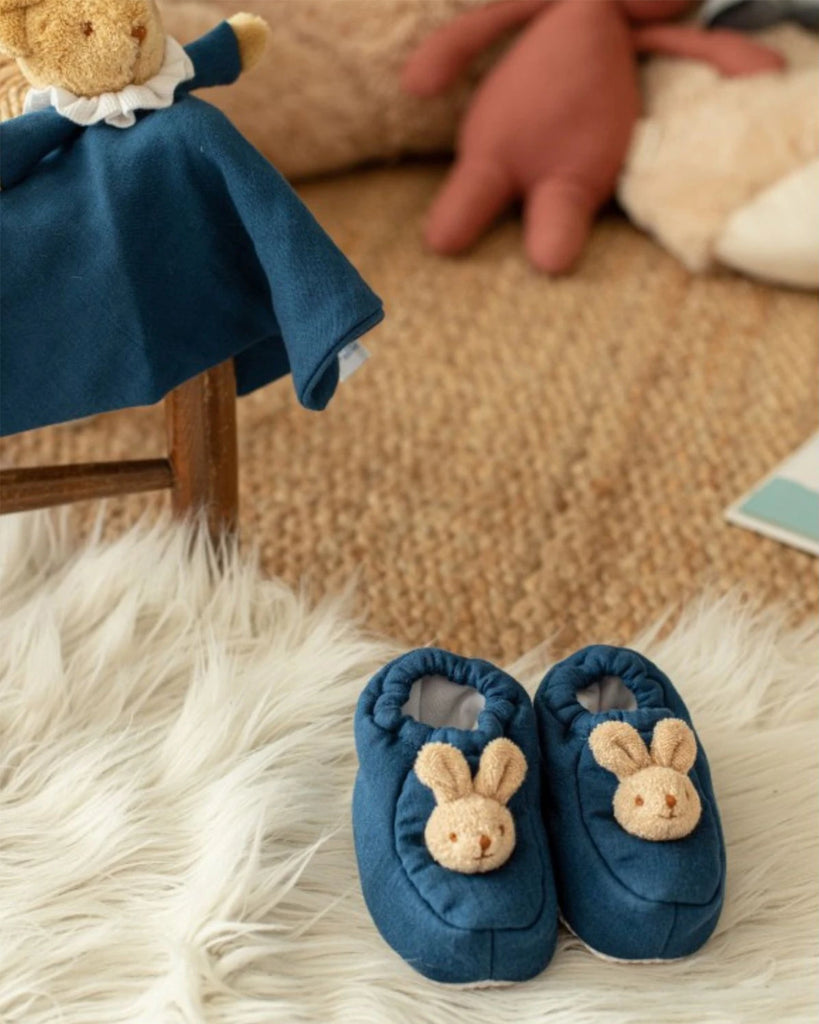 Vue des chaussons pour bébé bleu denim lapin de la marque Bobine Paris dans un joli décor.