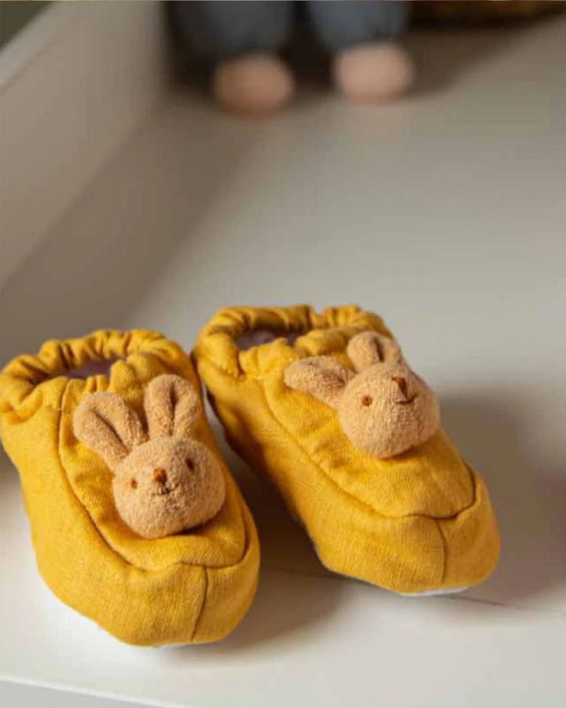 Léger zoom sur les chaussons pour bébé lapin jaune moutarde de la marque Bobine Paris.