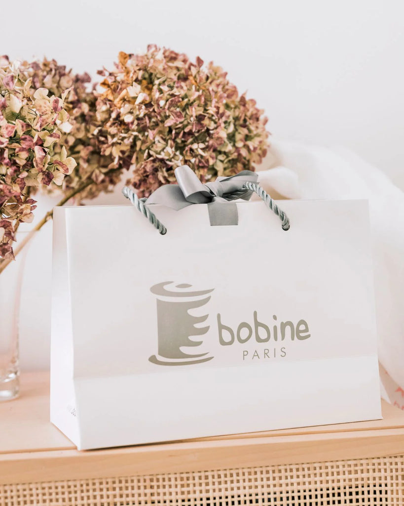 Sac pour bavoir rond en coton blanc à détails roses à personnaliser de la marque Bobine Paris.