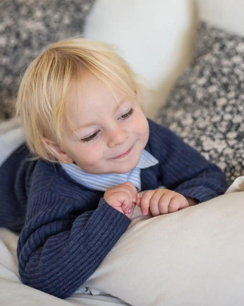 Photo d'un bébé garçon portant une tenue bobine paris composé du cardigan côtelé en laine et cachemire bleu outremer
