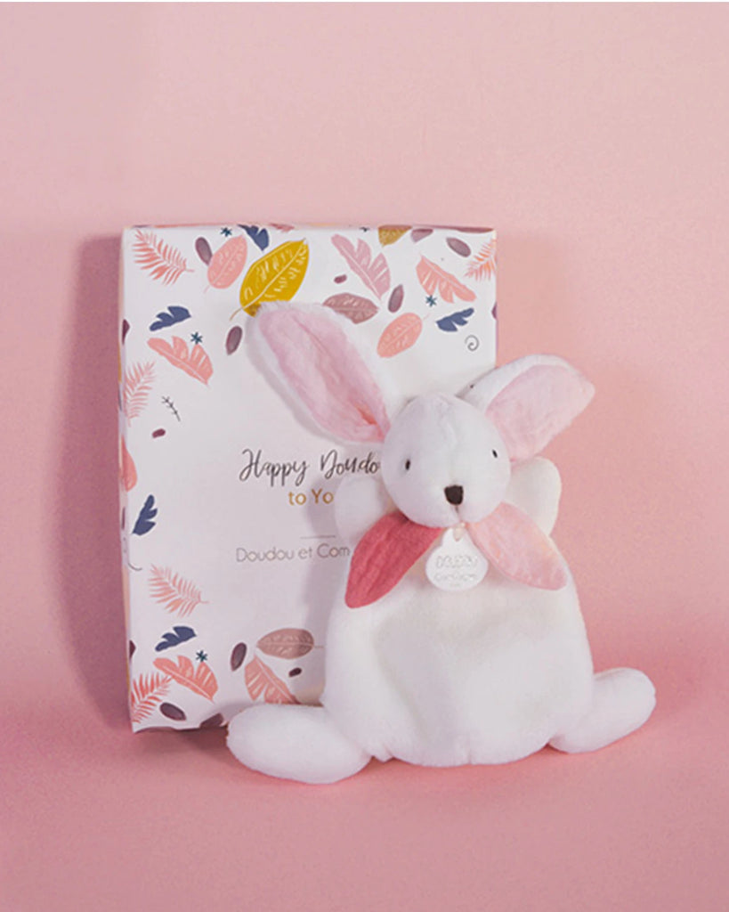 Doudou lapin pour bébé blanc et rose de la marque Bobine Paris avec sa boite sur fond rose