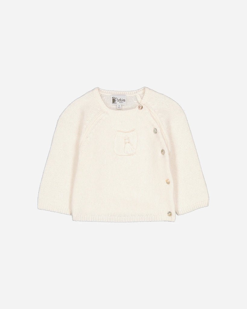Pull du look composé d'un ensemble écru en laine et cachemire et d'une chemise à rayures ciel de la marque Bobine Paris.