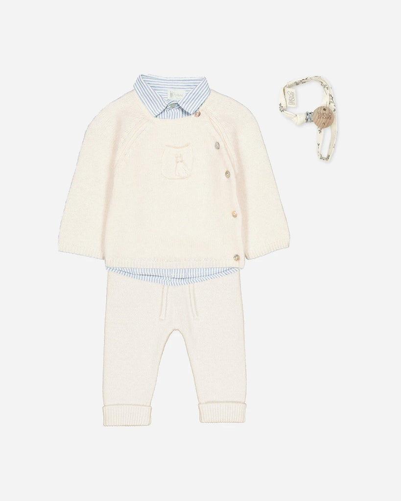 Look composé d'un ensemble écru en laine et cachemire, avec son pull cache-cœur et son pantalon assorti et d'une chemise à rayures ciel de la marque Bobine Paris.