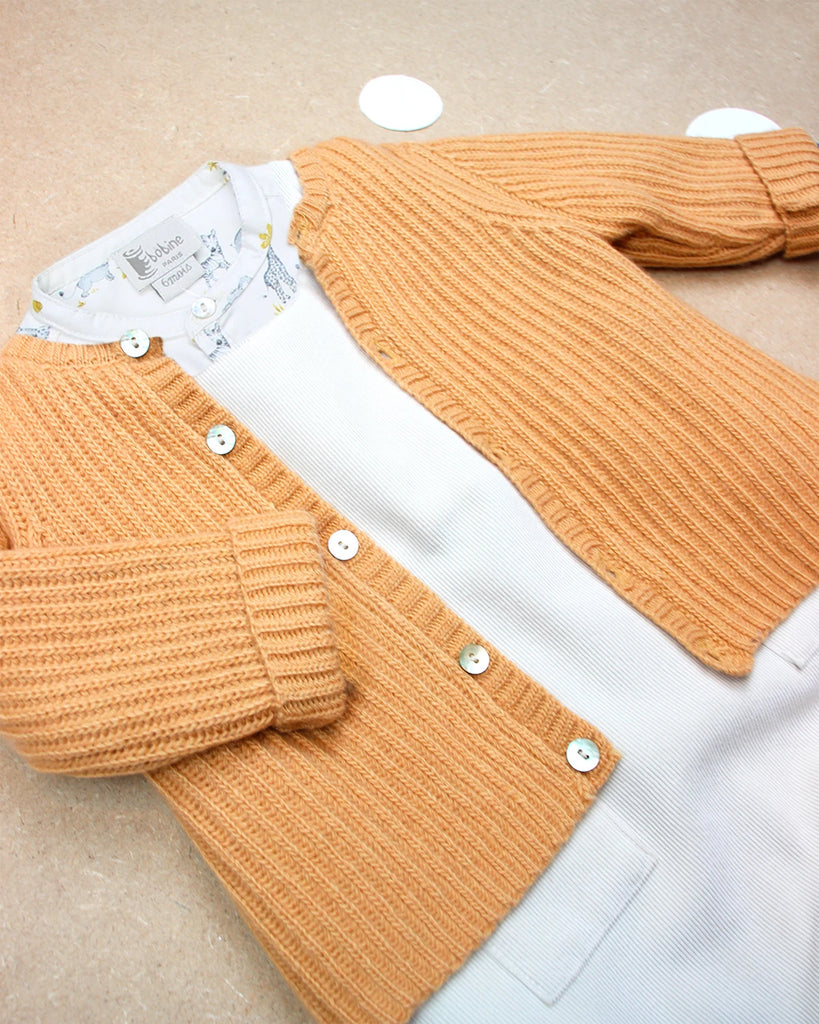 Look composé d'une chemise en coton à imprimé safari, d'une combinaison en velours et d'un cardigan couleur curry de la marque Bobine Paris.