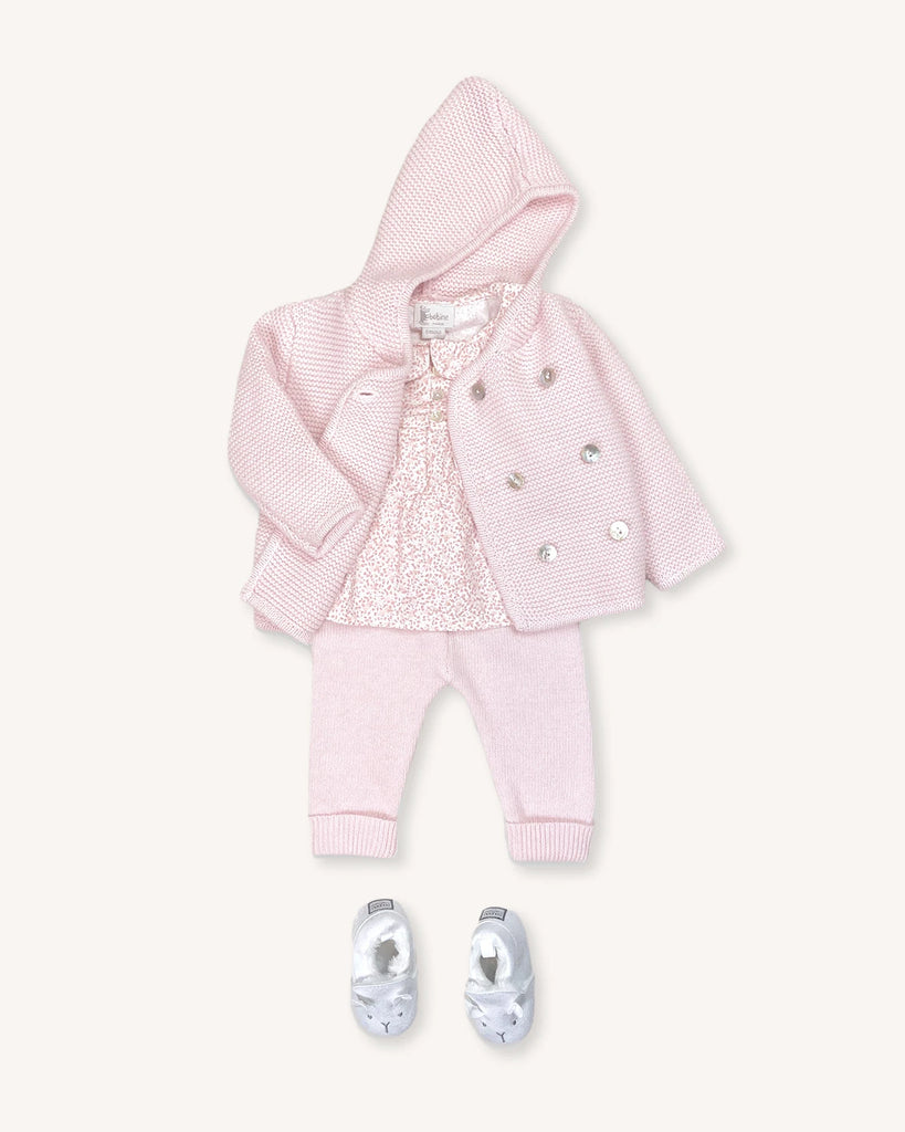 Look pour bébé fille composé d'une blouse fleurie rose et d'un ensemble veste à capuche et pantalon en laine et cachemire roses avec des petits chaussons de la marque Bobine Paris.