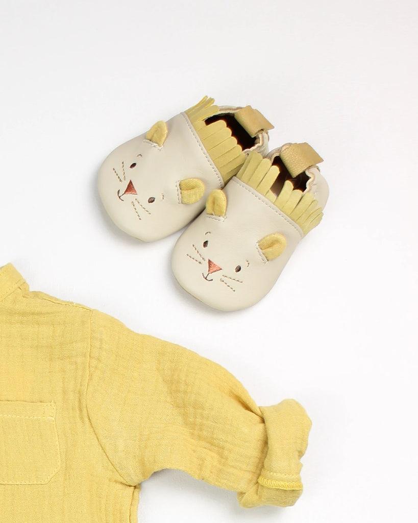 Chaussons pour bébé en cuir avec design lion de la marque Bobine Paris avec une chemise jaune en gaze de coton assortie.