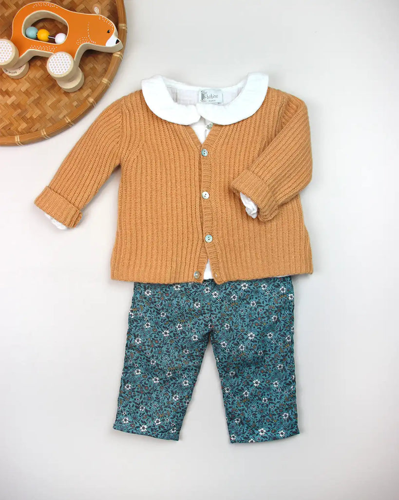 Look avec le pantalon bébé à fleurs turquoises et nœud à la taille de la marque Bobine Paris.