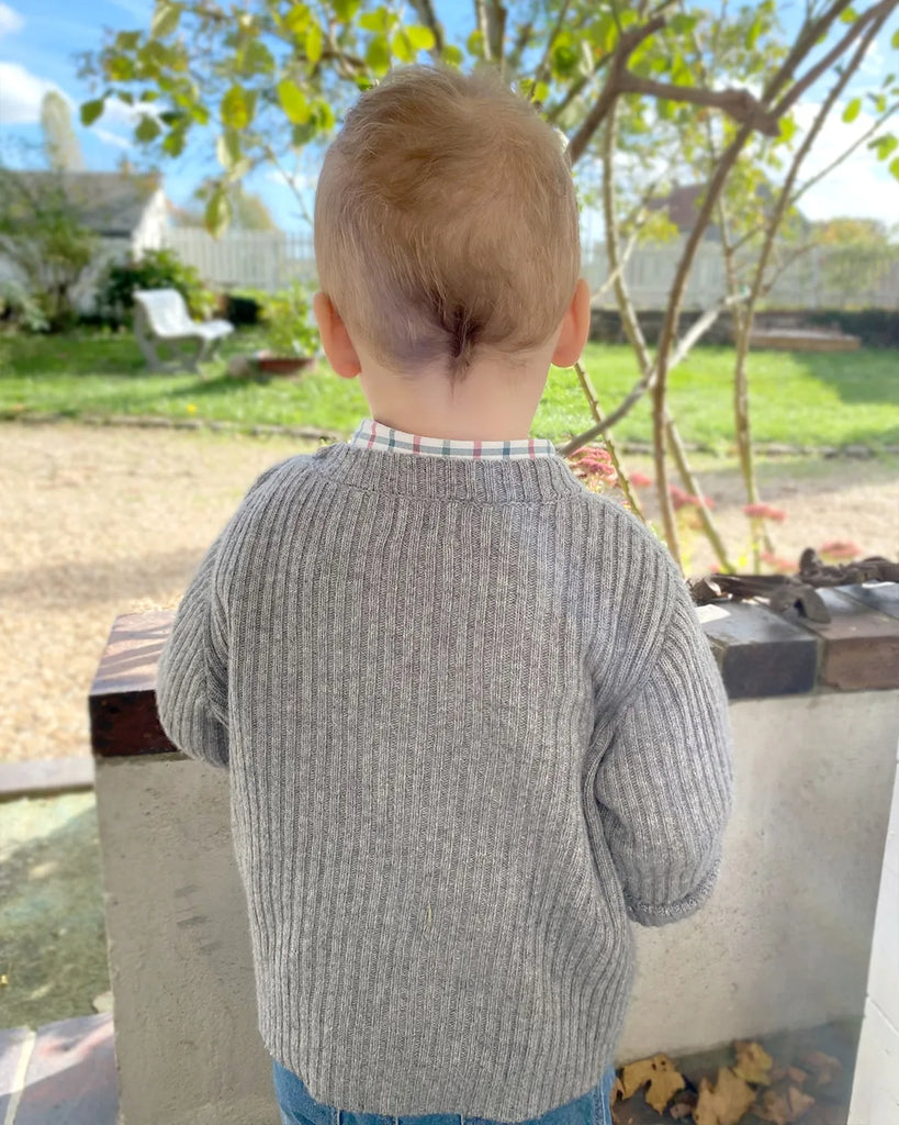 Vue de dos d'un petit garçon portant le pull tricoté en laine et cachemire gris moucheté de la marque Bobine Paris