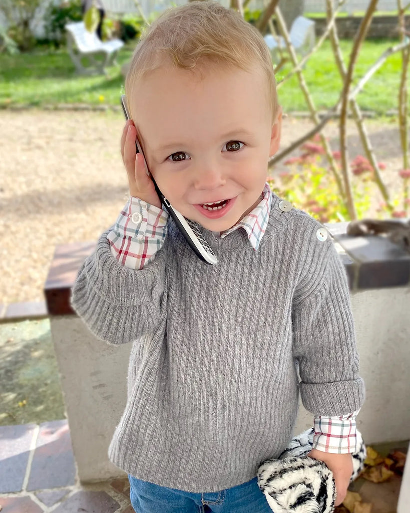 Image d'un petit garçon portant le pull tricoté en laine et cachemire gris moucheté de la marque Bobine Paris