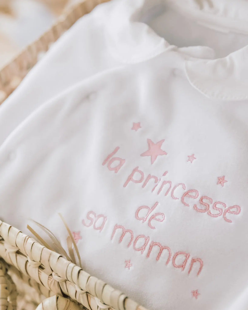 Zoom sur le pyjama en coton blanc en broderie rose "La princesse de sa maman" de la marque Bobine Paris.