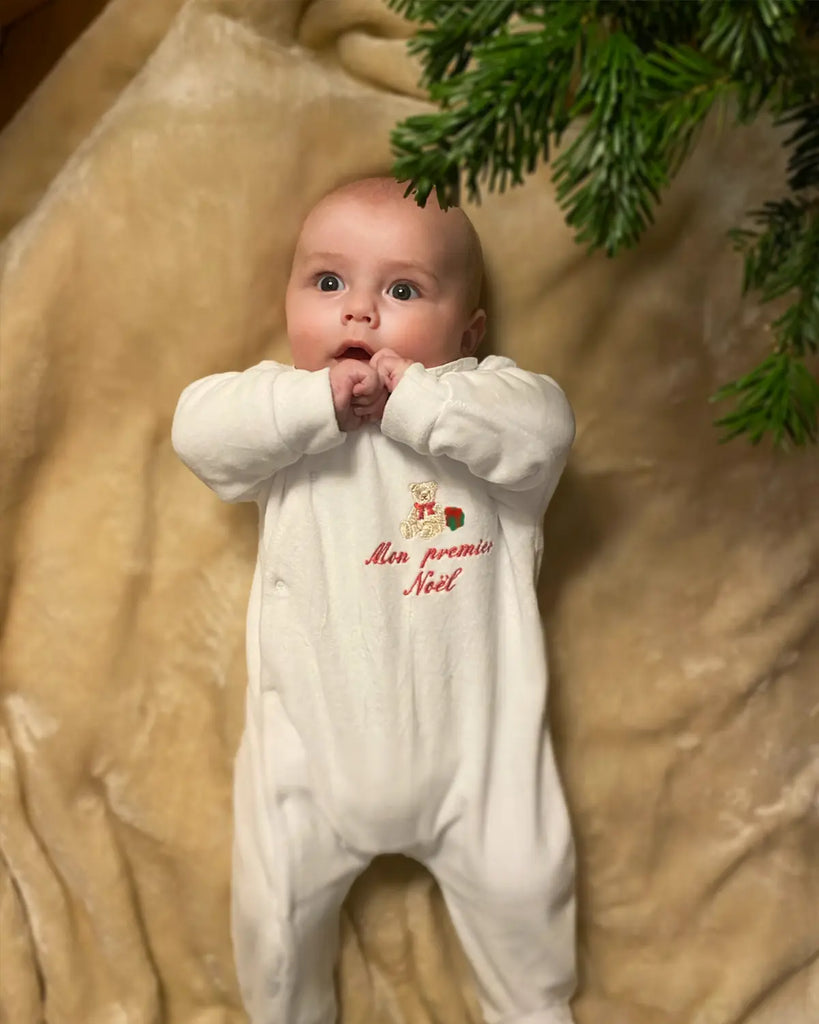 Vue portée du pyjama blanc pour bébé avec broderie ourson et "Mon premier Noel" rouge de la marque Bobine Paris.