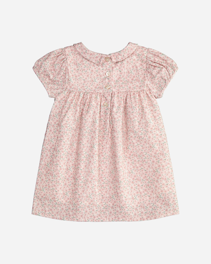 Vue de dos de la robe rose pour bébé fille en coton rose fleuri avec broderies roses et vertes, manches courtes bouffantes et col Claudine pointu de la marque Bobine Paris.