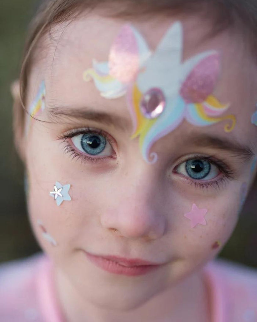 Petite fille portant des stickers pour visage en forme de licorne couleurs pastel