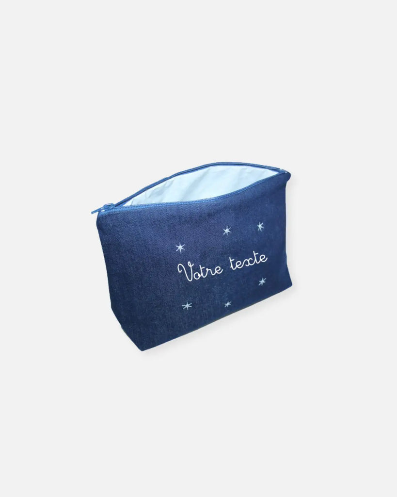 Vue de profil de la trousse de toilette bleu jean à broderie à personnaliser blanche de la marque Bobine Paris.