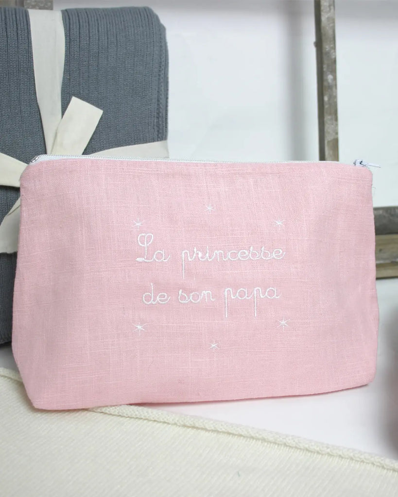 Image de la trousse de toilette pour bébé rose à broderie blanche "La princesse de son papa" de la marque Bobine Paris.