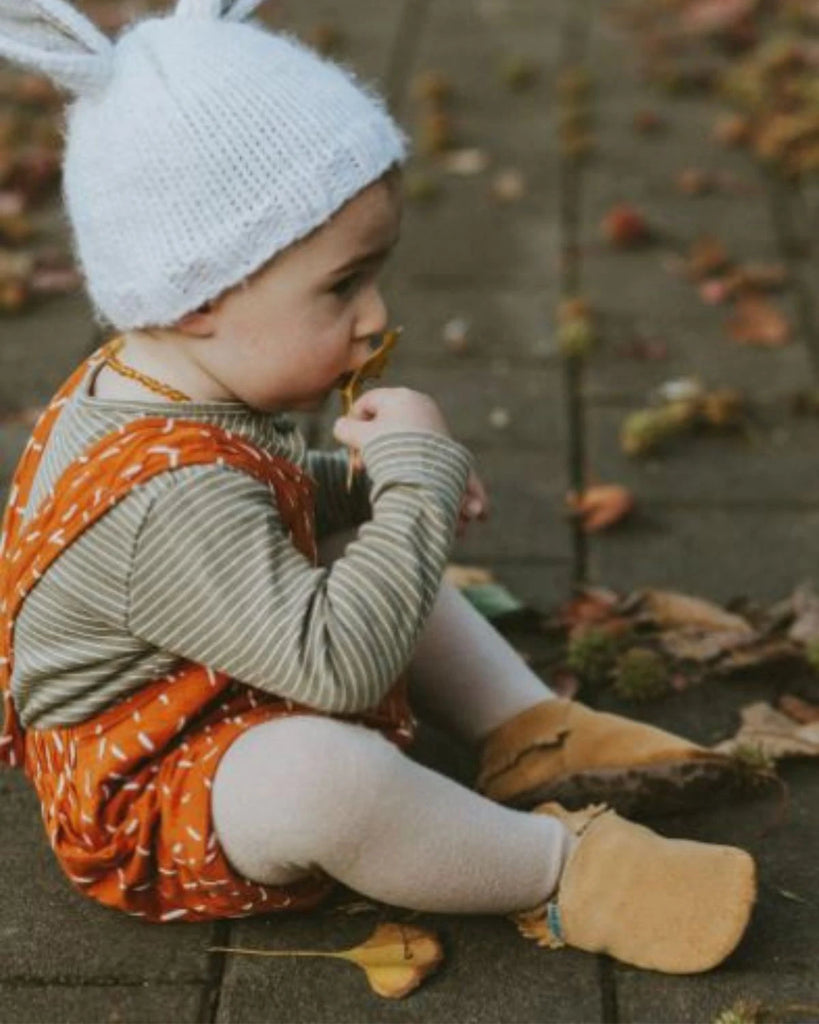 Chaussons mocassins pour bébé en daim beige de la marque Bobine Paris portés par un bébé.