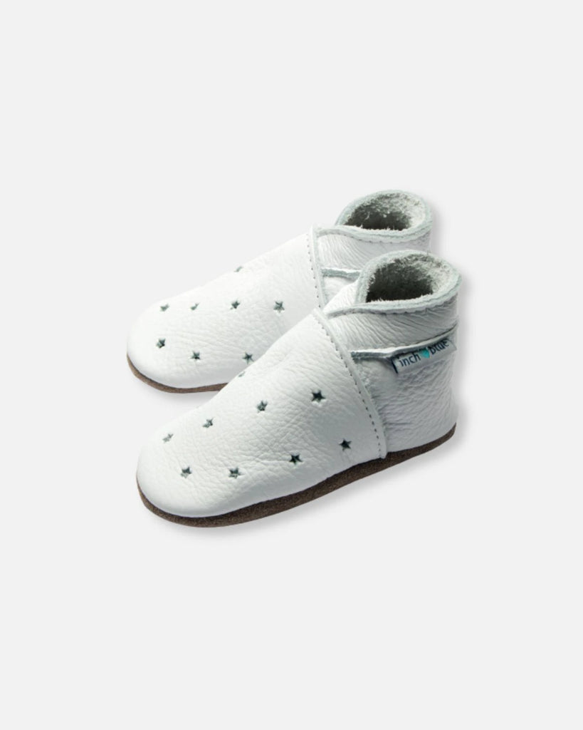 Vue de profil des chaussons pour bébé en cuir mou blanc étoilé de la marque Bobine Paris.