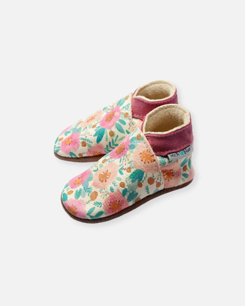 Vue de profil des chaussons pour bébé couleur crème et rose à motifs fleuris de la marque Bobine Paris