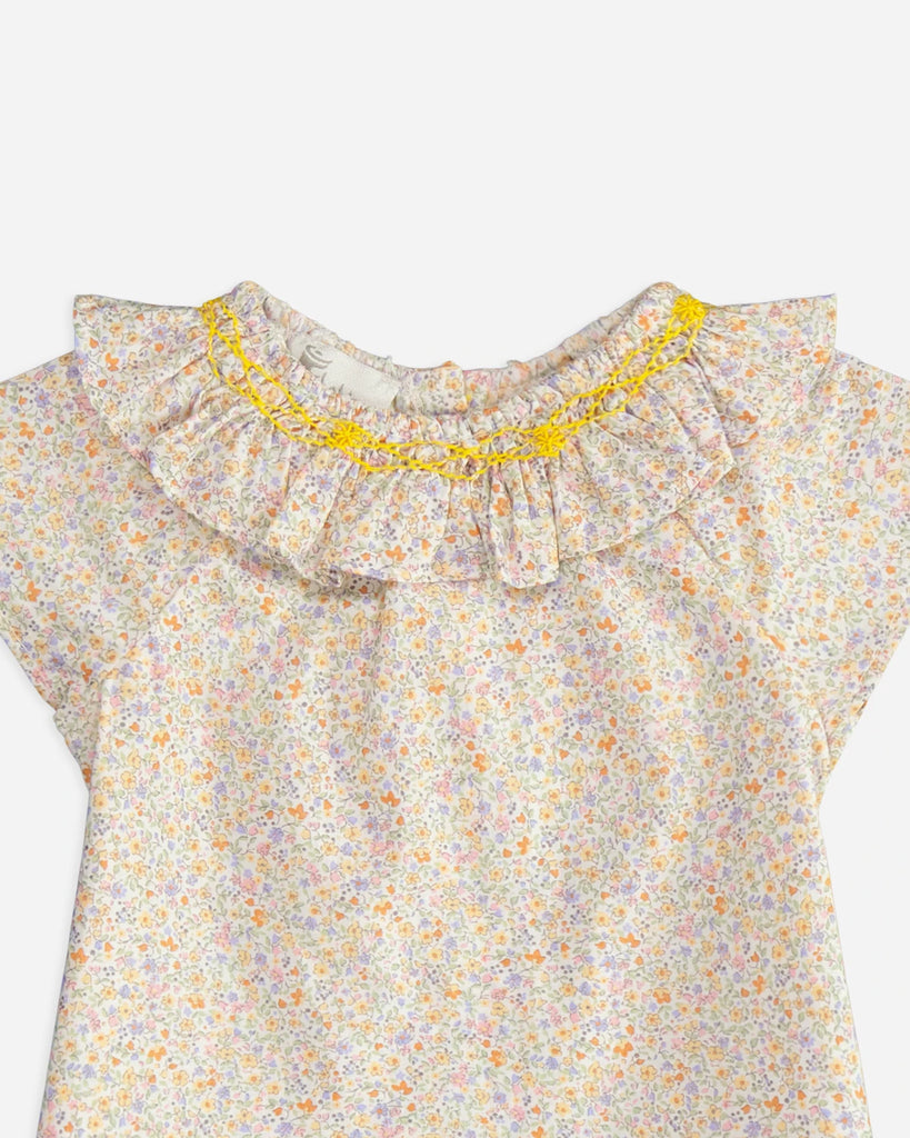 Zoom de la blouse pour bébé fille à col volanté et motif fleuri jaune de la marque Bobine Paris.