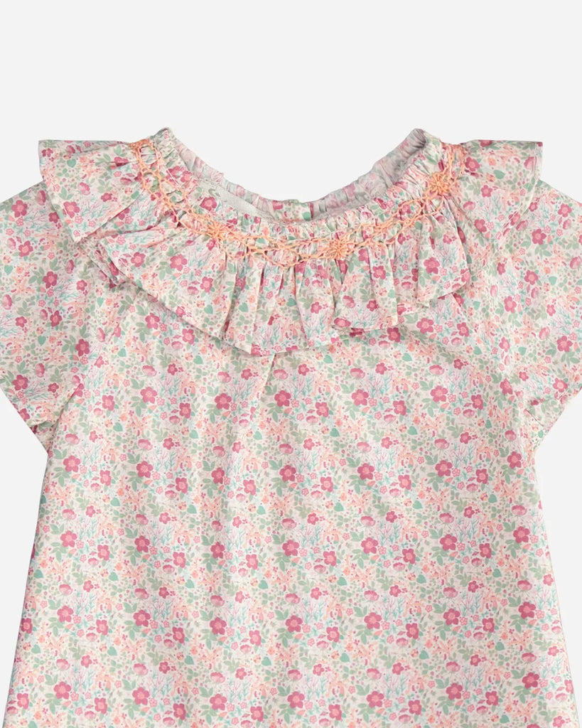 Zoom de la blouse à manches courtes, col volanté et motif fleuri rose orange et vert de la marque Bobine Paris.