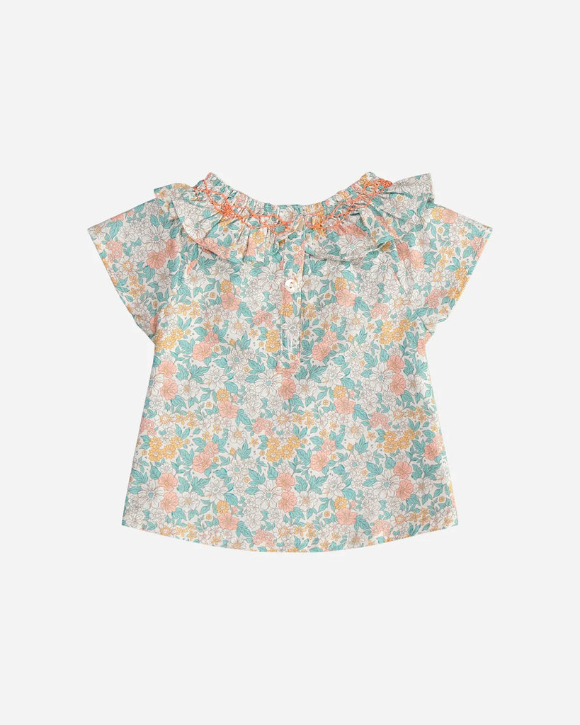 Vue de dos de la blouse pour bébé fille à col volanté et motif fleuri couleur amande et corail de la marque Bobine Paris.