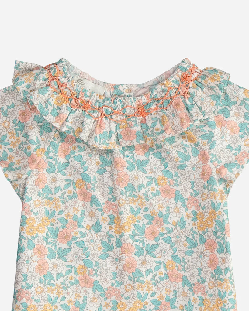 Zoom de la blouse pour bébé fille à col volanté et motif fleuri couleur amande et corail de la marque Bobine Paris.