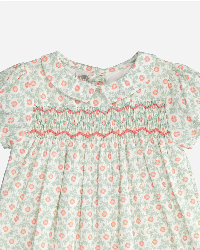 Zoom de la robe pour bébé fille en coton à imprimé vert pomme et à fleurs orange, à manches courtes bouffantes, col claudine affiné et à broderies vertes et orange de la marque Bobine Paris.