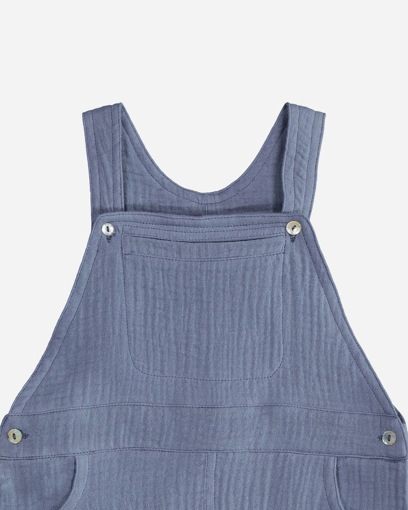 Zoom de la salopette pour bébé garçon en gaze de coton bleu jean de la marque Bobine Paris.