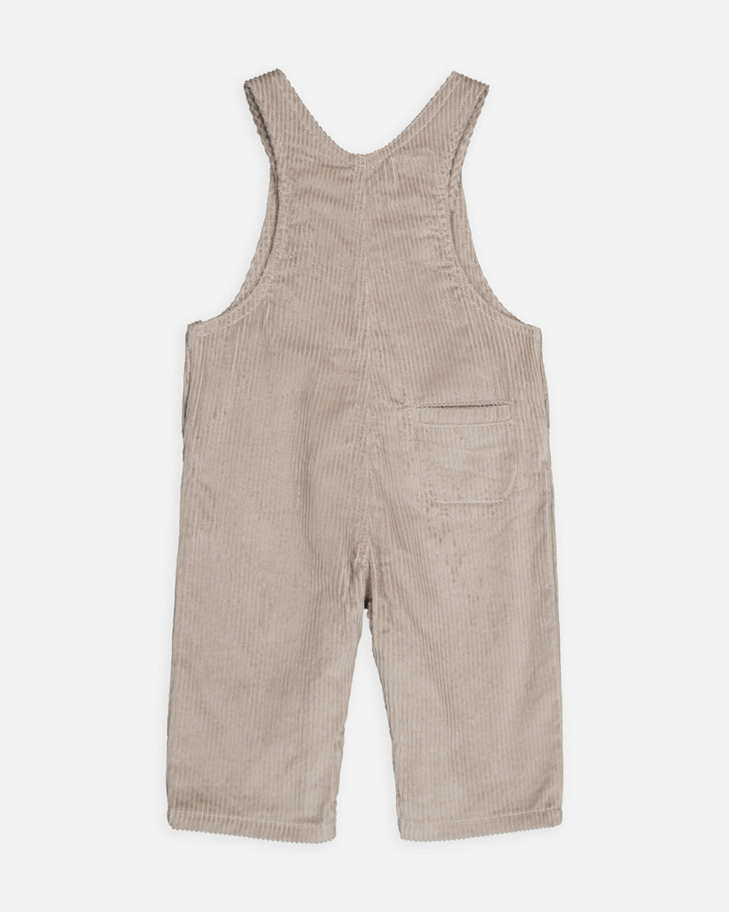 Vue de dos de la salopette beige sable velours avec une poche arrière à droite.