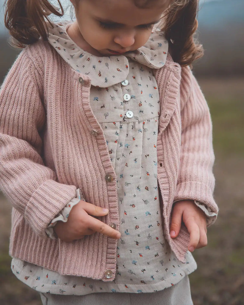 Zoom du cardigan rose poudre à côtes en laine et cachemire porté par une petite fille Bobine Paris